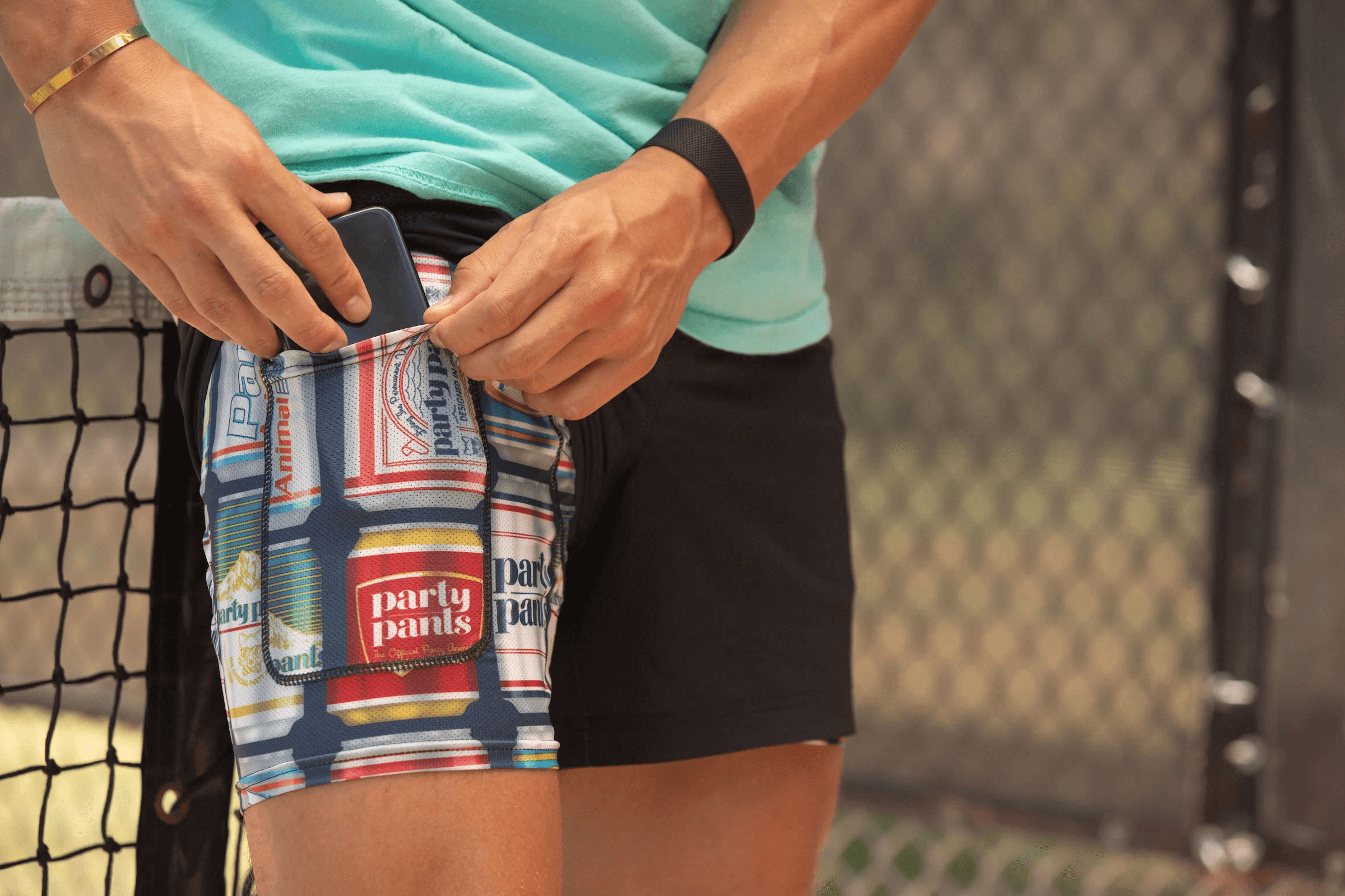 A guy putting his phone in the interior phone pocket of the Pour Choices Sport Lined Short - Navy