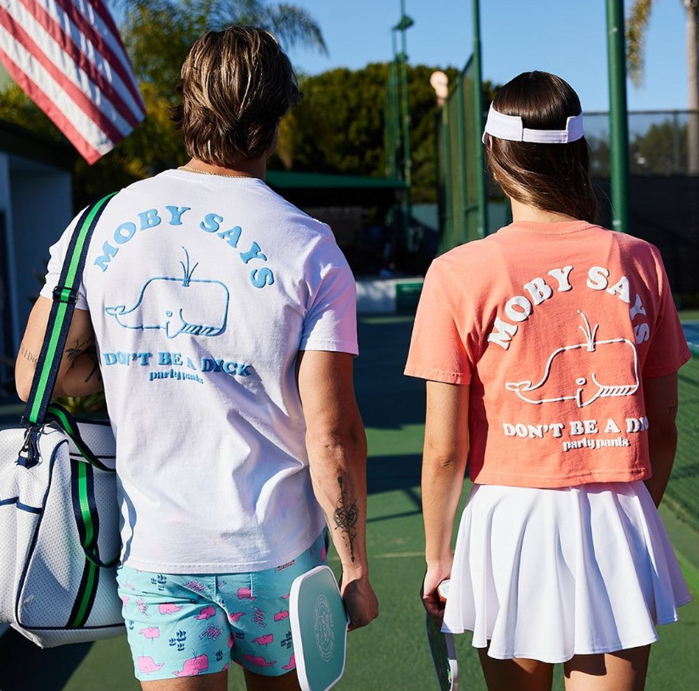 Two friends wearing Moby Says tees at a pickleball court