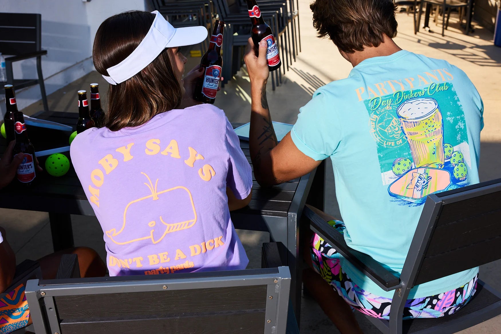 A man and woman drinking beers at a pickleball court