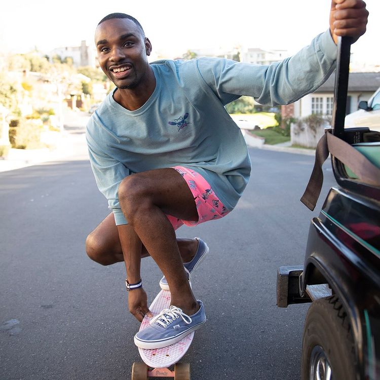 A guy wearing the Hammertime Party Starter Short while skateboarding