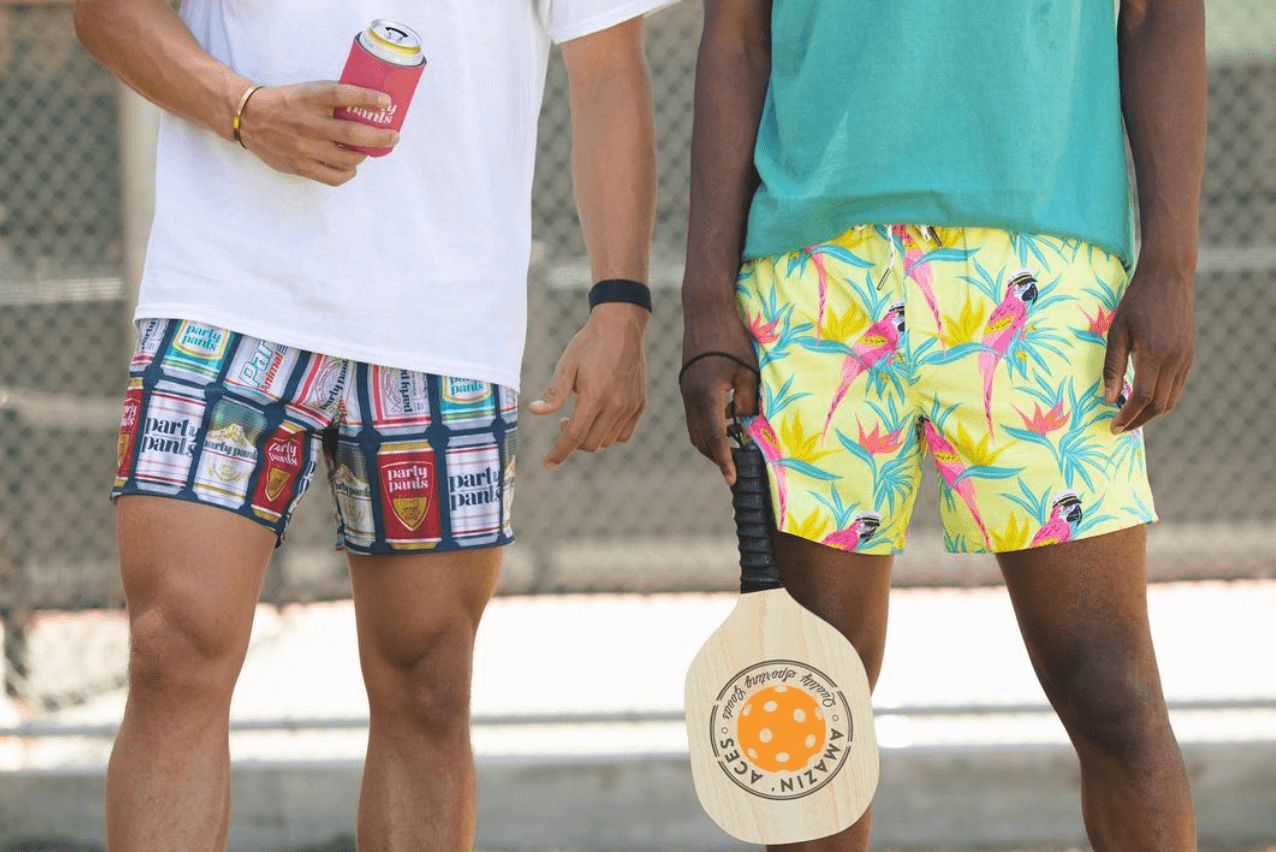 two guys wearing print shorts while playing pickleball