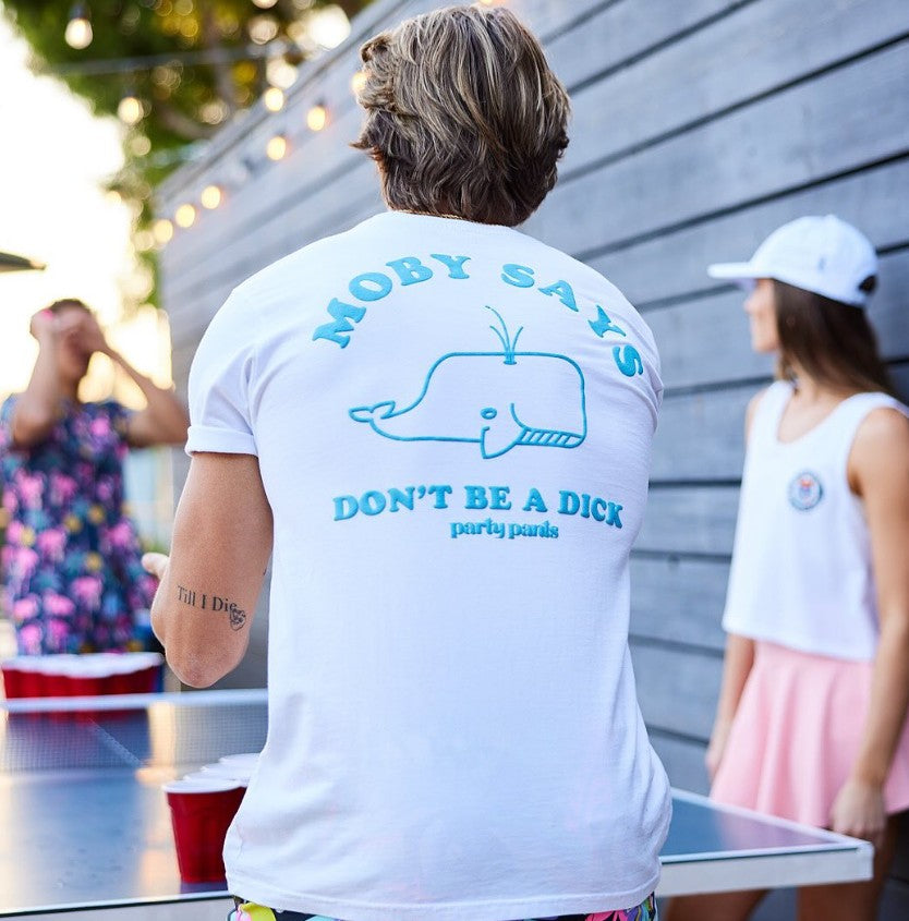 A guy playing beer pong wearing the Moby Says T-Shirt - White