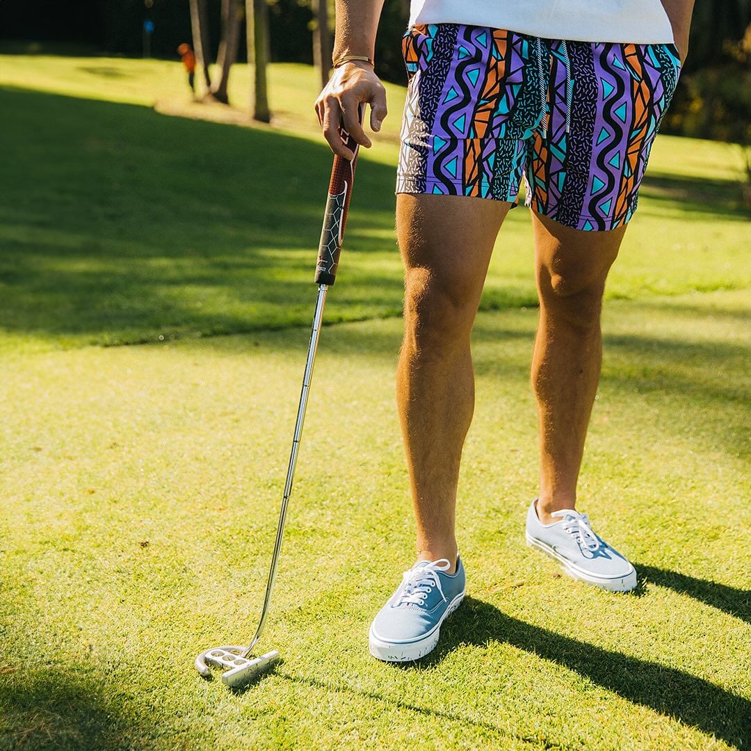 A guy on a golf course wearing the Maui Wowie Party Starter Short - Black
