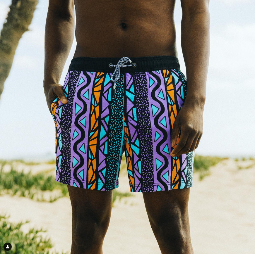A guy wearing the Maui Wowie Party Starter Short on a beach