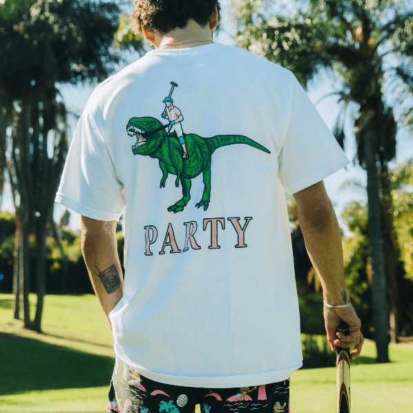 A guy wearing a dinosaur party shirt